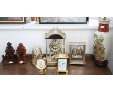 Four mantel clocks; a table lamp base; a carriage clock; a pair of carved treen ornaments.