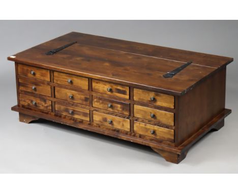 A Laura Ashley teak box-top table with a rectangular hinged lift-lid, fitted four racks of three long drawers to one side, &a