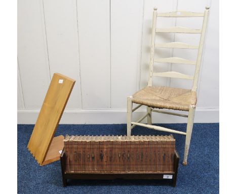 A early 20th century oak book trough with a selection of the "Punch Library of Humour", painted ladderback chair and a wooden