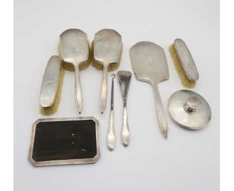 An eight piece silver dressing set, the bodies with engine turned decoration, by William Neale Ltd, Birmingham 1932, and a si