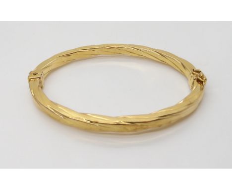 An Italian made 9ct gold bangle, inner diameters 6cm x 4.9cm, weight 7.1gms Condition Report:Available upon request