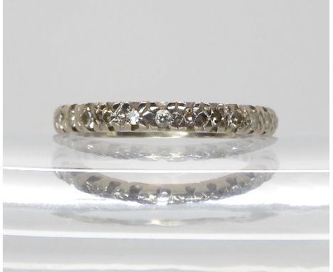 A white metal eternity ring set with diamonds (four tiny diamonds missing) finger size K, weight 2.7gms Condition Report:Avai