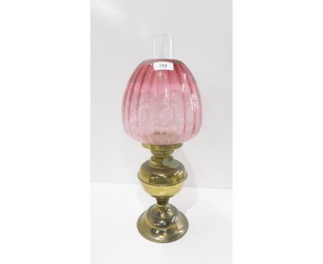 An oil lamp with cranberry glass shade Condition Report:Available upon request
