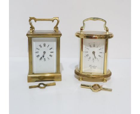 A French brass and glass cased carriage clock, and a Woodford brass and glass cased oval shaped carriage clock, both with key