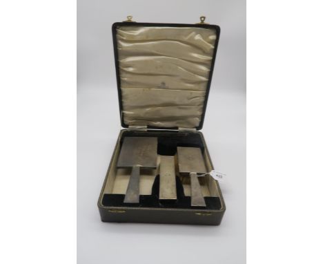 A cased silver three piece dressing set, comprising a hand mirror, clothes brush and hair brush, the bodies with engine turne