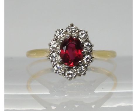 A bright yellow metal ruby and diamond cluster ring, dimensions of the ruby approx 6mm x 4mm, set with estimated approx 0.30c