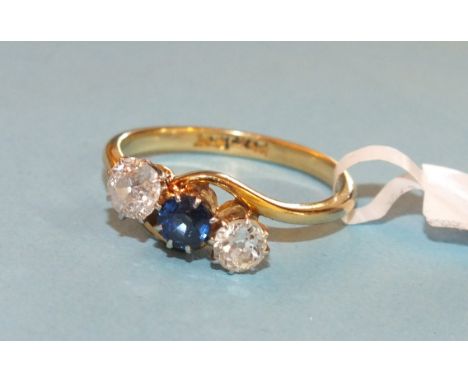 A sapphire and diamond ring claw set two brilliant cut diamonds and a round cut sapphire in 18ct yellow gold and platinum cro