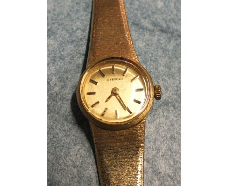 Eterna, a ladies 9ct gold wrist watch, the gold dial with baton numerals in 9ct gold case on integral textured gold bracelet,
