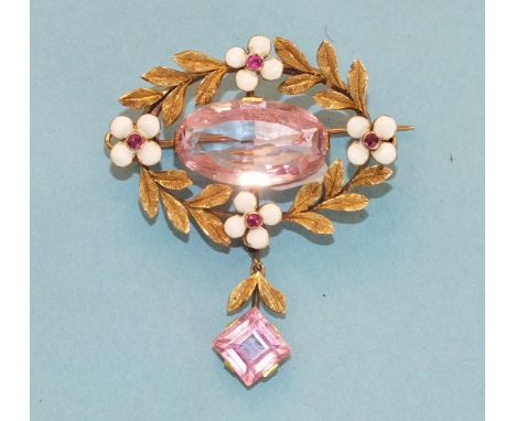 An oval wreath brooch/pendant centrally set an oval pink topaz of approximately 6.5cts within a gold wreath of leaves and fou