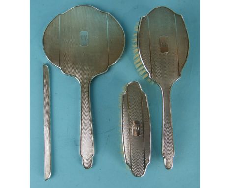 A four-piece silver-backed dressing table set with wavy engine turning, Birmingham 1957, (comb missing), (4).