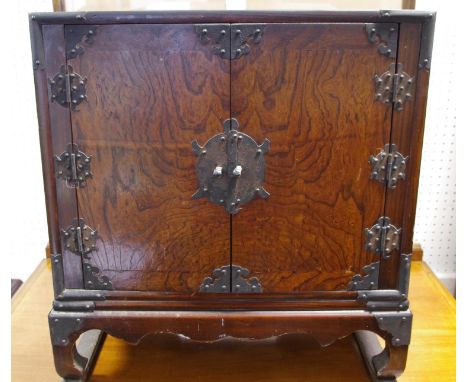 A Chinese style two door cabinet, resting on scroll feet, 53cm high,49cm wide