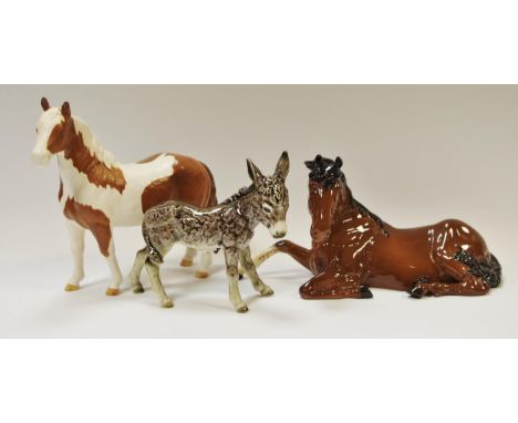 A Goebel donkey model, printed marks to base; a Beswick recumbent horse; another Beswick palomino horse (3)