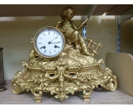 A 19th century gilded mantle clock of romantic form showing a young child viewing a mirror set on a rustic bank, the movement