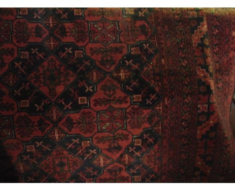 A Persian style red ground carpet with abstract medallion centre upon a red field within further running borders