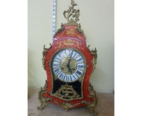 A 19th century style French bracket clock, the waisted case in timber overlaid with metallic mounts, the dial with enamelled 