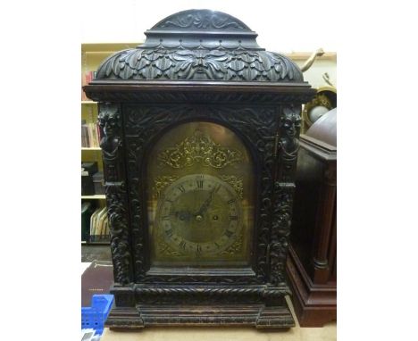 A substantial Victorian oak bracket clock, the oak case heavily carved with green man and floral, geometric and other decorat