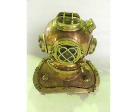 A model of a 19th century diver's standard helmet with extensive mounts and applied detail in brass, encasing glazed panels t