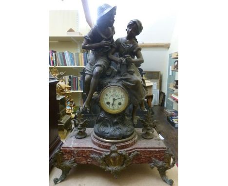 A 19th century continental mantle clock in spelter, the small eight day striking movement surmounted by a rural boy and girl 