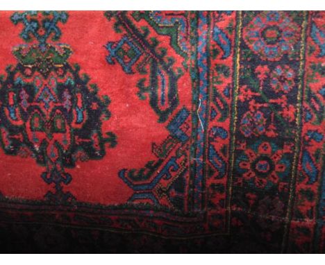 A large Turkey wool carpet with typical red ground overlaid with geometric green, blue geometric detail, 320 x 270 cm approx