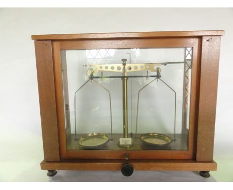 A vintage cased set of Gallenkamp apothecary scales set within a timber case with glazed panelled sides and brass instrument 
