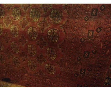 An Afghan red wool carpet, the multi medallion centre within alternating borders 320 x 200 cm approx