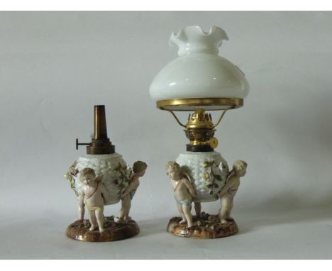 A pair of late 19th century continental lamp bases of globular form with simulated basket weave moulding and floral encrusted