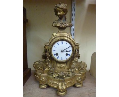 A 19th century gilded mantle clock, the case with floral swag, scroll and female bust decoration enclosing an eight day strik