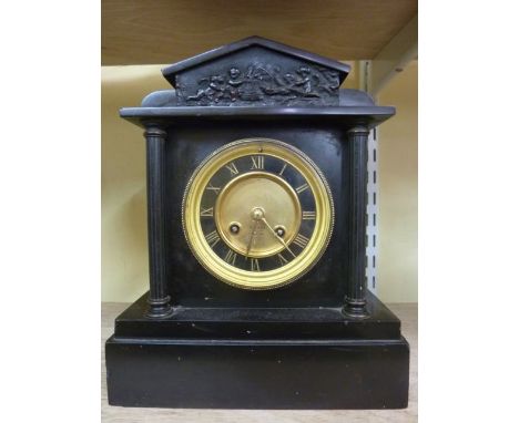 A Victorian black slate mantle clock in the classical style with reeded column supports enclosing an eight day striking movem