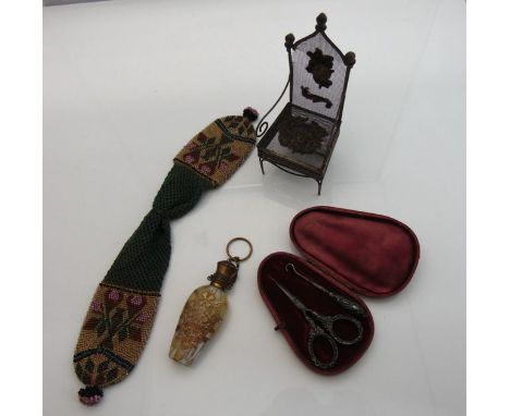 A 19th century glass perfume bottle overlaid with a floral design in gilt work, a cased pair of Victorian scissors and button
