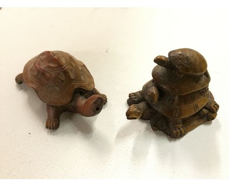 A carved netsuke of a stack of three tortoises and another carving of a tortoise.