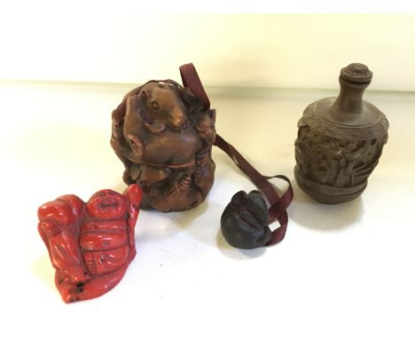 A carved red coral Buddha, a resin scent bottle and a resin imro and netsuke.