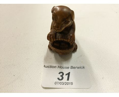A small netsuke of a dog with a basket. 45 mm