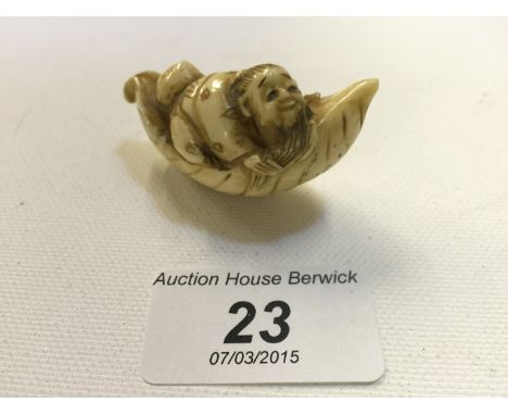 A late 18th century ivory netsuke of a man in a small boat. 50 mm long.