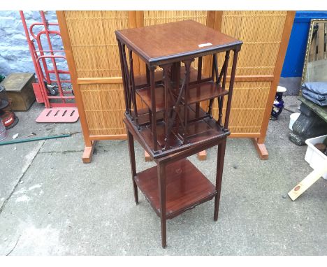 A revolving bookcase mounted on a lwer section with a shelf.