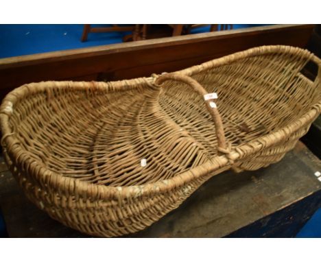 A vintage wicker fruit or flower basket, width approx. 110cm, with raised centre possibly for donkey or horse assistance