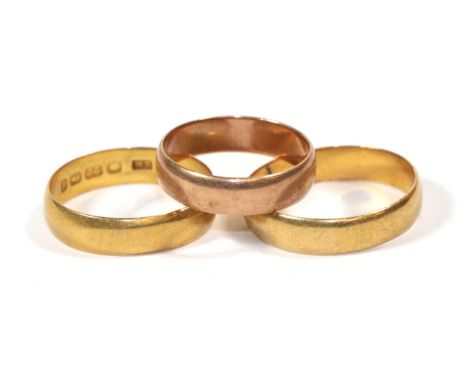 Two 22 carat gold band rings, finger sizes N1/2 and P1/2; and a 9 carat gold band ring, finger size K1/2 (3).  Two 22 carat g