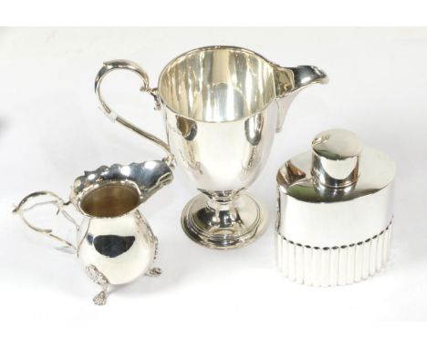 A George V silver helmet shaped cream-jug, by Richard Comyns, London, 1932; an Elizabeth II silver cream-jug on three foliage