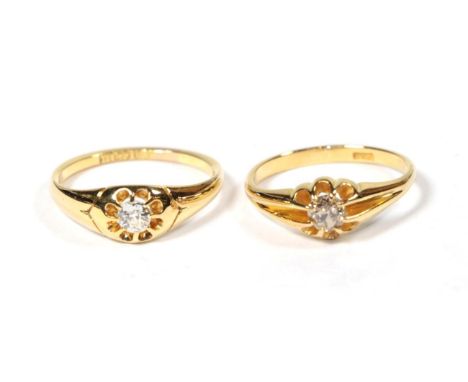 An 18 carat gold diamond solitaire ring, finger size M1/2; and a diamond solitaire ring, stamped '18CT', finger size M (2) . 