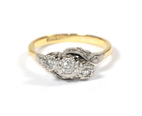 A diamond three stone twist ring, stamped '18CT and PLAT', finger size R .  Gross weight 4.17 grams. 