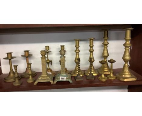 SHELF OF BRASS CANDLESTICKS, (8)