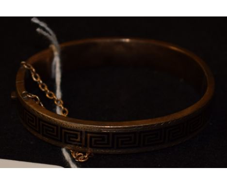 A Victorian pinchbeck and black enamel Grecian revival hinged bangle with a continuous Greek key band, c.1870