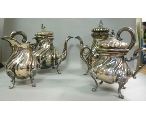 A four piece Continental silver coloured metal tea set of wrythen moulded cauldron design, on foliate scroll cast feet  compr