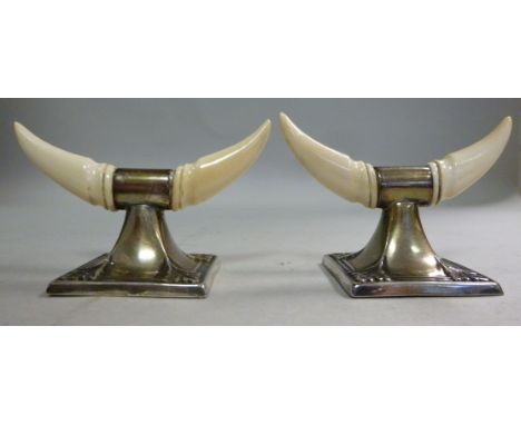 A pair of Edwardian silver and carved ivory cattle horn knife rests, on square, foliate embossed stands  Hilliard & Thomason 