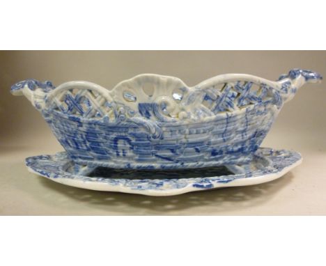 An early 19thC Spode Pearlware oval, moulded, pierced basket on a matching saucer, decorated in blue and white with figures a