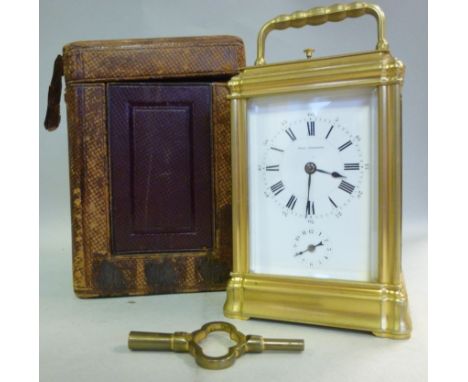 An early 20thC lacquered brass cased carriage clock, having bevelled glass panels and a folding top handle, on a plinth; the 