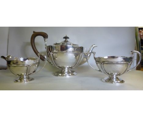 A three piece silver tea set of circular, segmented, pedestal bowl design  comprising a teapot, having a swept spout and a ca