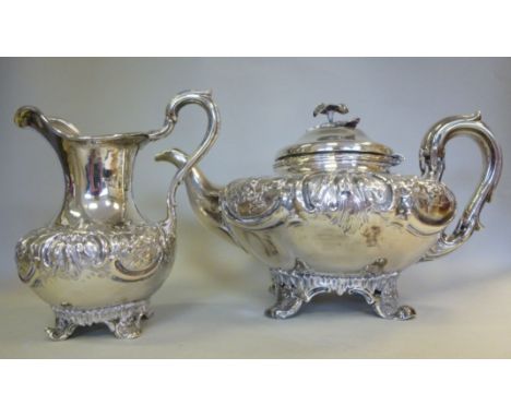 An early Victorian silver teapot of squat, bulbous form, cast and chased with flora and scrolls, having a high loop handle, a