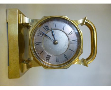 An early 20thC lacquered brass cased timepiece of octagonal drum design, set to the top with a compass and a carrying handle,