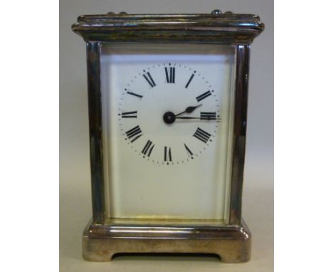 A mid 20thC silvered brass cased carriage timepiece, having bevelled glass panels and a folding top handle, on a bracket plin