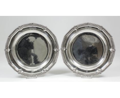 A pair of George IV silver plates, the shaped rims with bold gadroon and shell pattern mounts, 10.25ins diameter, by Paul Sto